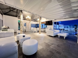 Relax in a stylish space with a central dining table, comfortable seating areas, and a flat-screen TV.