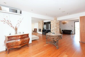 Relax in this stylish living area with a large table, dresser, and comfortable seating.