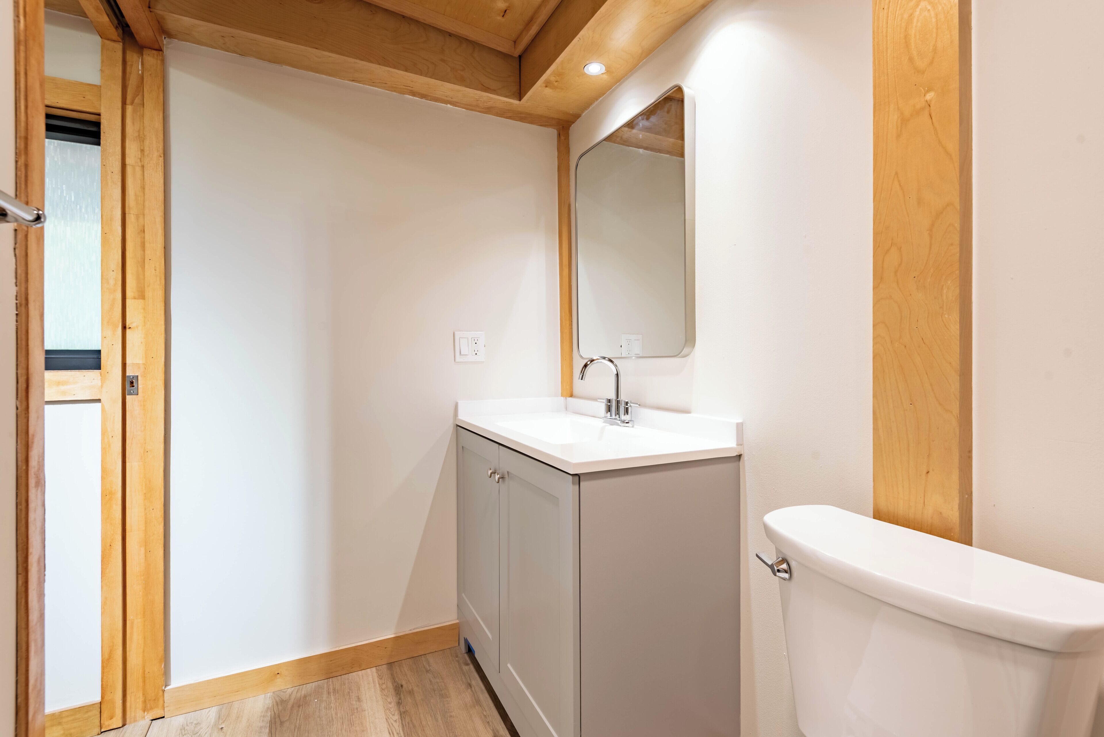 A small bathroom with a white sink, a mirror, and a toilet.