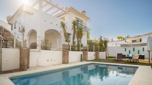 A swimming pool with a white building in the background. - Luxurious home in Viñuela (Viñuela)