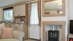 Een gezellige woonkamer met een bank, een open haard en een televisie.