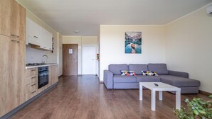 A modern apartment with a kitchen, a grey sofa, and a painting on the wall. - Beautiful apartment in Rakovica with WiFi (Rakovica)