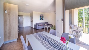 A modern living room with a sofa, a dining table with chairs, and a balcony with outdoor furniture. - Beautiful apartment in Rakovica with WiFi (Rakovica)