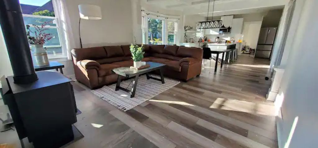 A modern living room with a brown sectional sofa, a coffee table, and a fireplace.