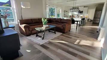A modern living room with a brown sectional sofa, a coffee table, and a fireplace.