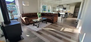 Uma sala de estar moderna com um sofá seccional marrom, uma mesa de centro e uma lareira.