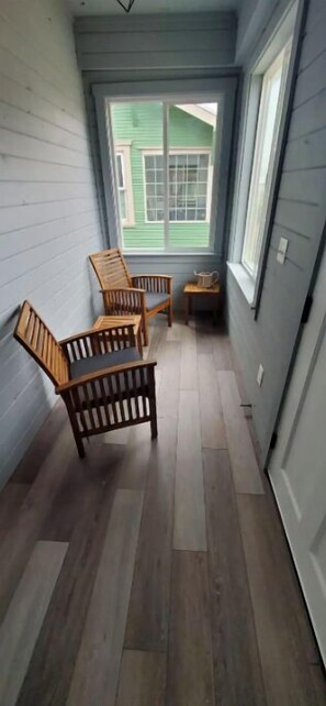 Enter a cozy space with a sloped ceiling, leading to a bright room with a large window.