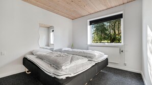 A bedroom with a bed, a window, and a radiator.