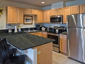 Fully equipped kitchen with oven, microwave, and refrigerator.