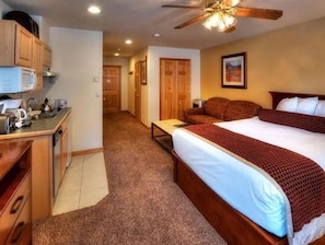 Relax in comfort with a large bed, wooden nightstand, and convenient desk area.