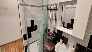 A bathroom with a glass-enclosed shower, a white sink, and a mirror above the sink. - Rooms Argo (Cres)