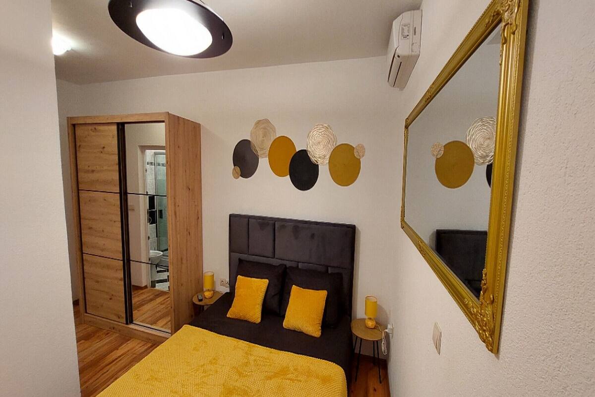 Un dormitorio con cama, espejo y pared decorada con círculos.
