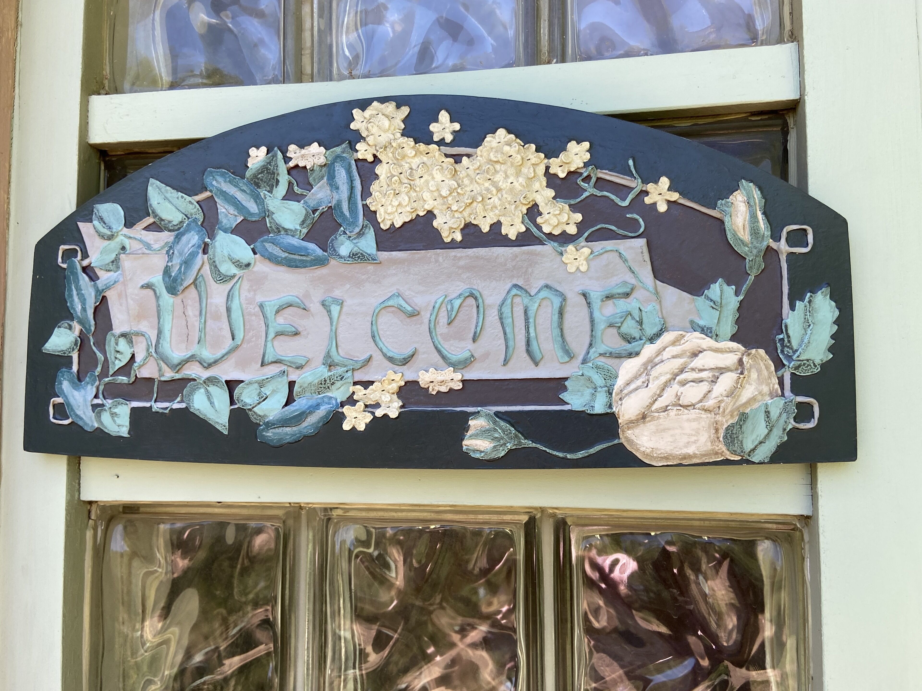 Un panneau d’accueil décoratif orné de motifs floraux et de feuilles.