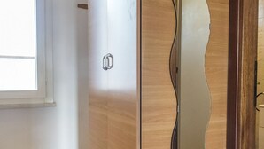 Una puerta de madera con un panel de vidrio ondulado y un tirador de metal.