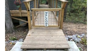 A wooden deck with a 'WELCOME' sign leading to a house.