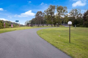 Ein Golfplatz mit einer gewundenen Bahn, amerikanischen Flaggen und einem Schild mit der Aufschrift 'Travelogue'.