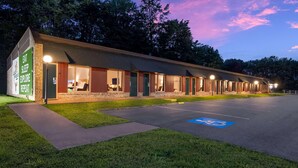 Un motel comprenant plusieurs chambres, un parking et un espace verdoyant.