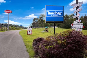 Een Travelodge bord met richtingsborden voor nabijgelegen locaties.