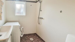 A small, compact bathroom with a washing machine, a shower, and a window. - Cozy home in Uddevalla (Uddevalla)