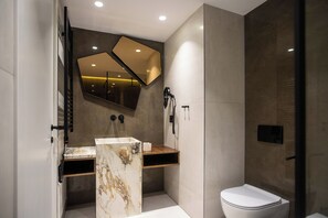 A modern bathroom with a marble vanity, a toilet, and a shower area. - Elisa Hotel Tirana Affiliated By Melia (Tirana)
