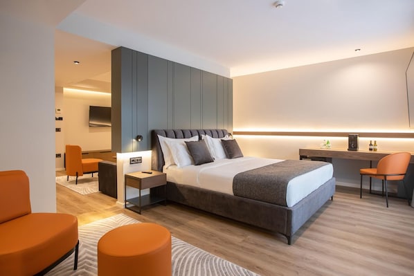 A modern hotel room with a large bed, a desk, and a seating area. - Elisa Hotel Tirana Affiliated By Melia (Tirana)