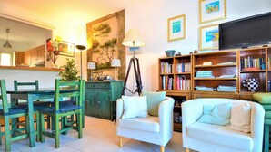 A living room with a dining area, a bookshelf, and a painting on the wall. - Stunning home in Aigues-Mortes with WiFi (Aigues-Mortes)