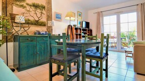 A cozy dining area with a wooden table and chairs, a teal cabinet, and a bookshelf. - Stunning home in Aigues-Mortes with WiFi (Aigues-Mortes)