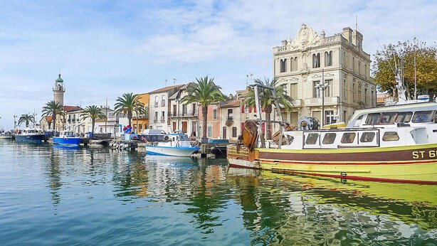 A marina with boats docked along a waterfront, featuring historic buildings and a prominent tower. - Stunning home in Aigues-Mortes with WiFi (Aigues-Mortes)