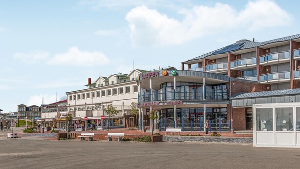 A modern building with a restaurant named "LUZIFER" and a sign for "RESTAURANT KNEIPE". - 1 bedroom amazing apartment in Büsum (Büsum)