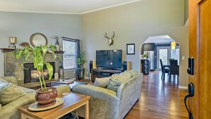 A living room with a fireplace, a television, and a sofa. - Home w/ Hot Tub: 7 Mi to Edmonds Waterfront! (Lynnwood)