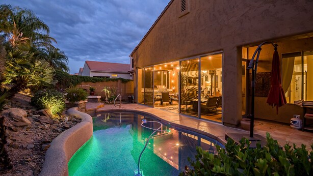 A modern house with a swimming pool, large glass doors, and a well-maintained garden. - Scottsdale Grayhawk entire house with Private Pool, Sunroom, Office (Scottsdale)