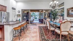 A modern kitchen with a bar area, dining space, and a view of the outdoors. - Scottsdale Grayhawk entire house with Private Pool, Sunroom, Office (Scottsdale)