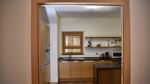 Eine kleine Küche mit Holzausstattung, einem Fenster und einer Mikrowelle.