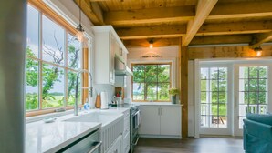Une cuisine moderne dotée de grandes fenêtres, d’un panneau indiquant qu’il s’agit d’une plage privée et offrant une vue sur l’extérieur.