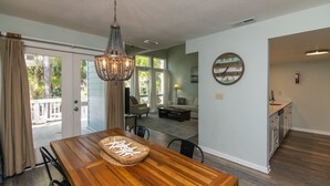 Een eethoek met een houten tafel, een kroonluchter en uitzicht op de omgeving.
