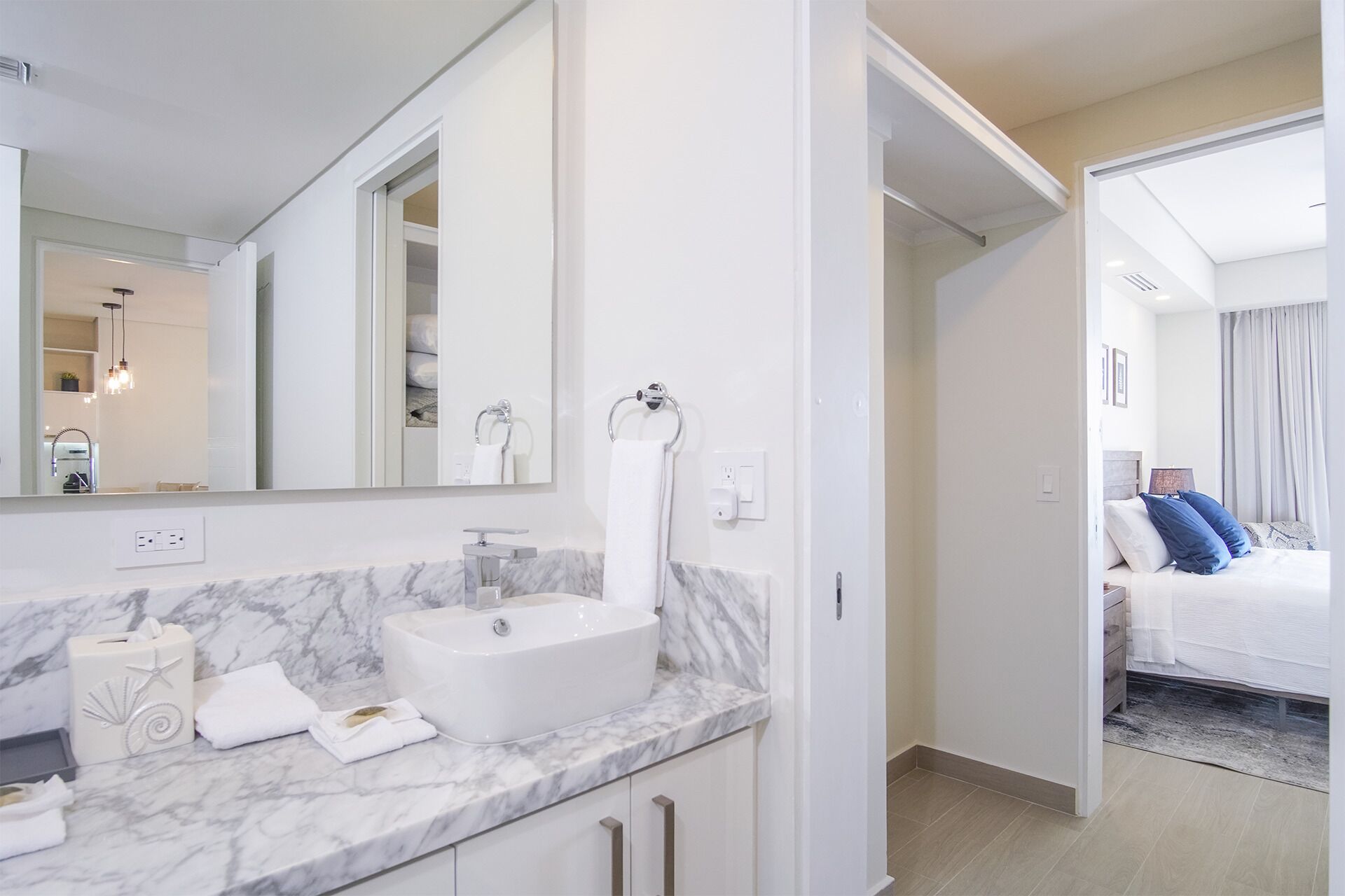 A modern bathroom with a marble countertop, a sink, and a mirror.