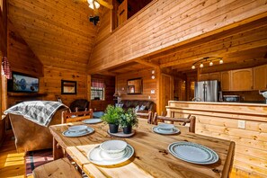 Cozy cabin-style dining area with a wooden table and chairs, perfect for a meal.