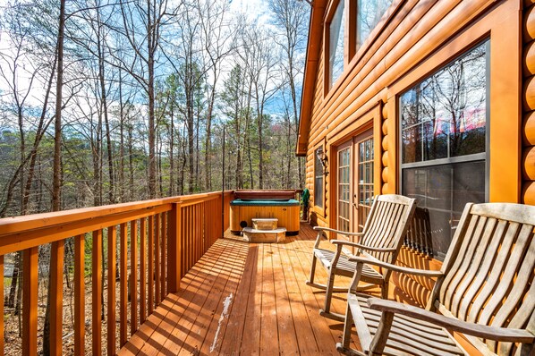 Relax on the deck with a hot tub and comfortable seating, taking in the breathtaking views of the surrounding forest.