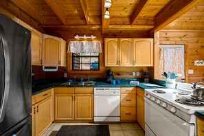 Kitchen features a central island, stainless steel appliances, and a sink.