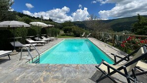 A rectangular pool with clear blue water, surrounded by stone tiles. There are lounge chairs and umbrellas along the poolside. - Beautiful private villa with private pool, hot tub, A/C, WIFI, TV, panoramic view, close to Cortona (Sant'angiolo)