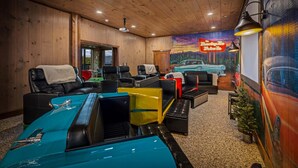 Ein Zimmer mit Holzwänden und -decken, ein Wandgemälde eines Autos an der Wand sowie ein altes Automodell im Vordergrund.