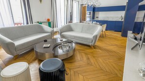A modern living room with two grey sofas, a round coffee table, and a black drum.