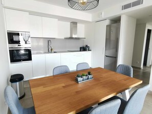 Enjoy cooking in this well-equipped kitchen with a central island, stainless steel oven, and sleek range hood.