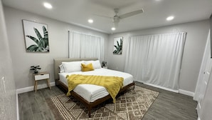 A bedroom with a bed, a nightstand, a ceiling fan, and a patterned rug. - Right off the main Weeki Wachee River! Beautiful updated home! (Spring Hill)