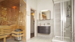 A modern bathroom with a glass shower enclosure, a wooden sauna, and a minimalist vanity. - Haus Sternschnuppe - comfortable house with fireplace, sauna, garden, terrace - (Wiek)