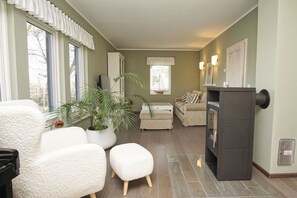 A living room with a fireplace, a sofa set, a coffee table, and a potted plant.