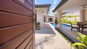 A pathway leading to a pool area with a number 205 sign on the left. - Villa Lipa Talay Sawng (Koh Samui)