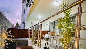 A modern outdoor balcony with a wooden bench, potted plants, and a railing. - Beautiful luxury 2-Bed Apartment in Pereybere (Grand Baie)