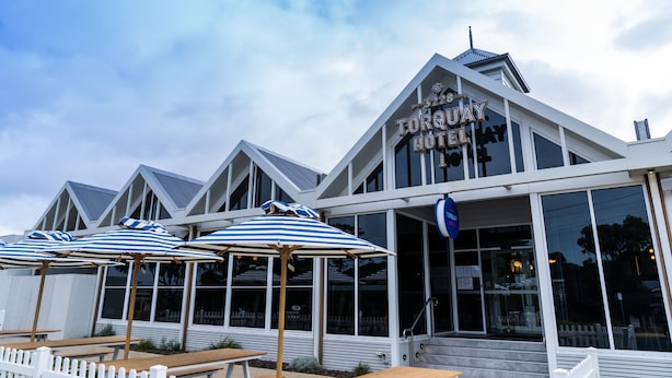 The exterior of Torquay Hotel with a modern design, featuring large windows and a white picket fence. - Torquay Hotel Motel (Torquay)