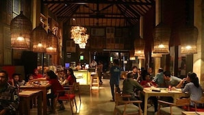 Een restaurant met houten meubels en hanglampen.